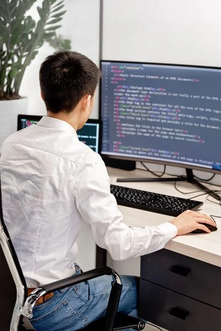 High-angle view of a stylish work desk featuring dual monitors, keyboard, mouse, and modern accessories.